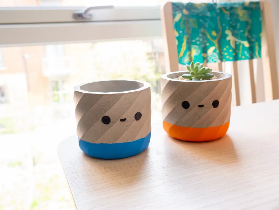 Two plant pots with faces on sitting beside each other